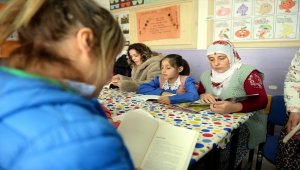 Köylüler sınıfta çocuklarıyla kitap okuyor
