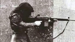 İngiliz ordusuna karşı bir savaşta yaralanan nişanlısının silahıyla ateş eden bir kadının 1972'de İrlanda'da çekilen bir fotoğrafı
