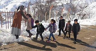 Sobayı yakıp okul yolunu kardan temizleyerek öğrencilerini karşılıyor